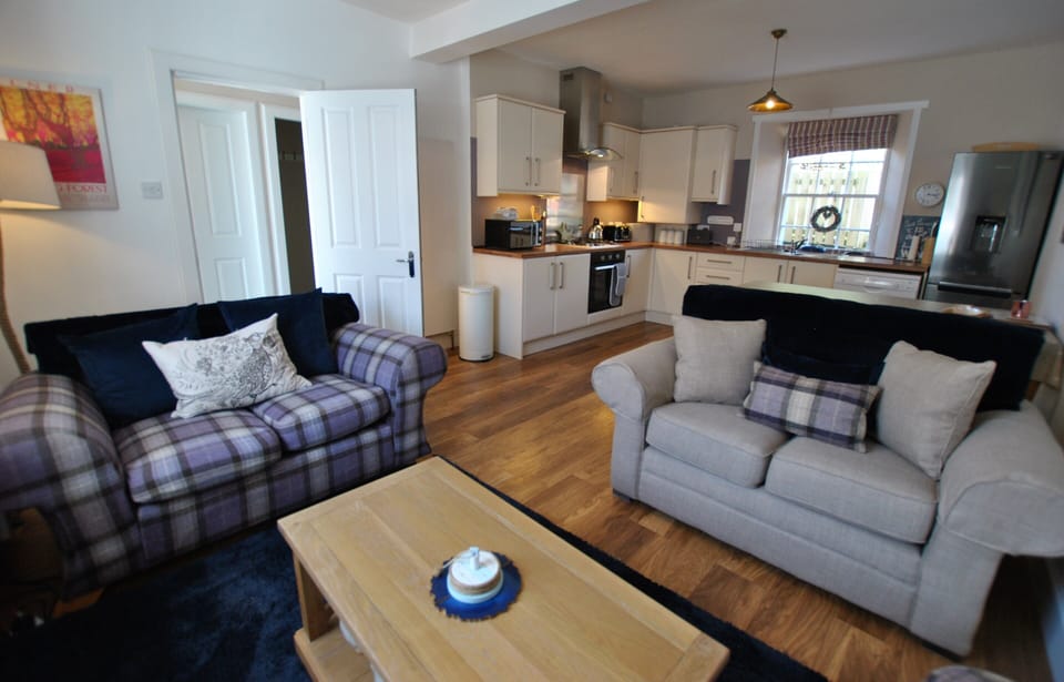 The entrance hall leads into the dining kitchen which has seating area and garden views