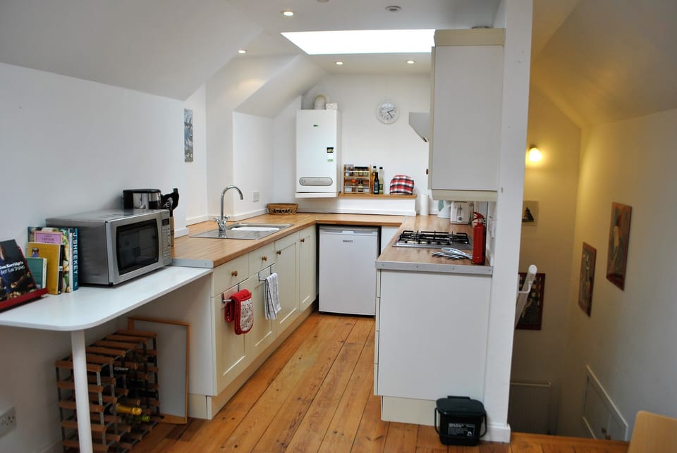 The clean, modern kitchen is flooded with light from the overhead window