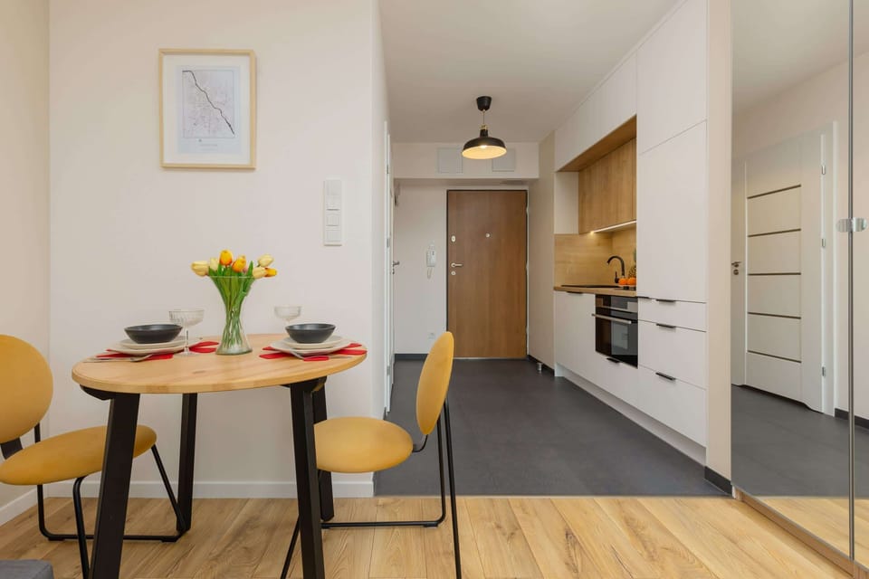 A bright kitchen and dining area with wooden finishes, yellow accents, and modern design.





