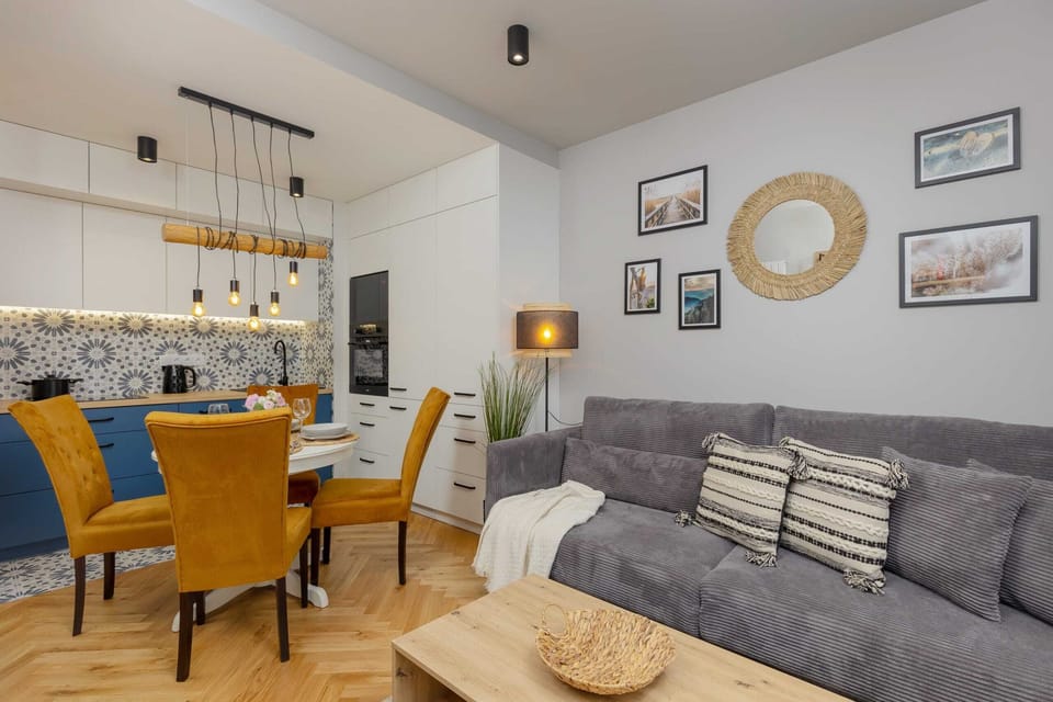 A spacious open-plan living and dining area, featuring bright yellow chairs and modern furnishings.
