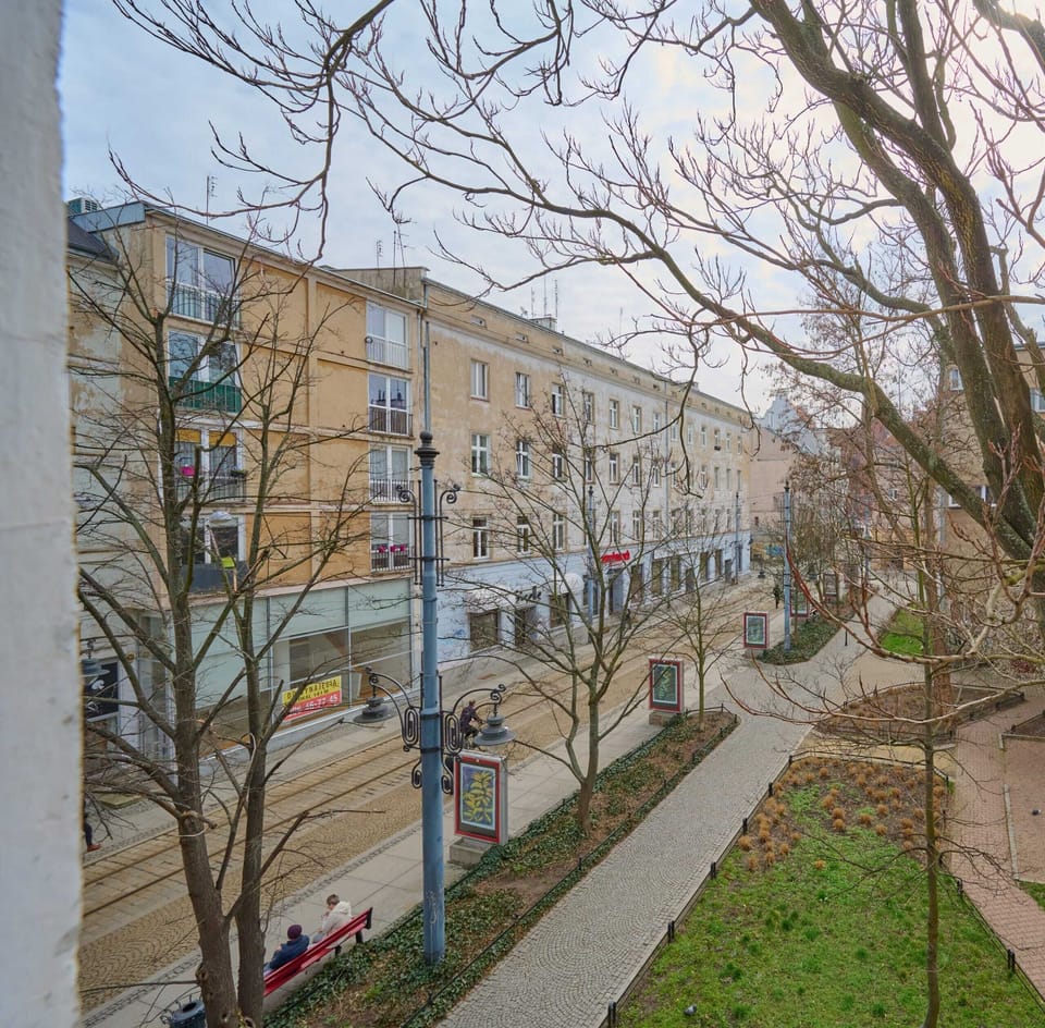 An exterior view of the apartment building, surrounded by greenery and a peaceful neighborhood.





