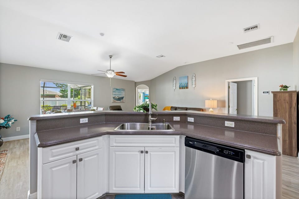 Bright open kitchen with bar seating and seamless flow to dining and patio.
