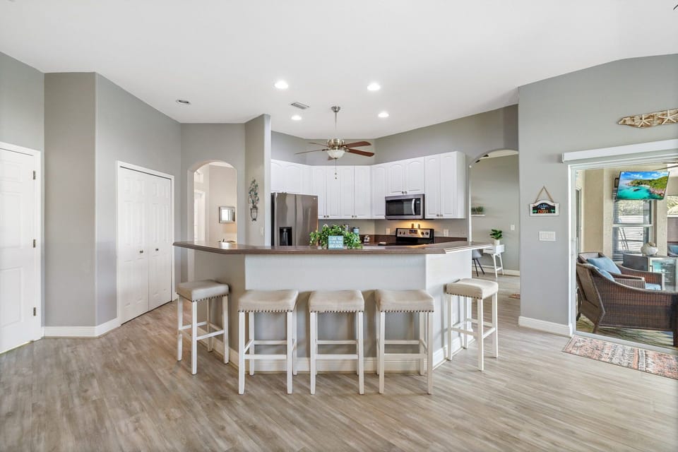 Bright open kitchen with bar seating and seamless flow to dining and patio.