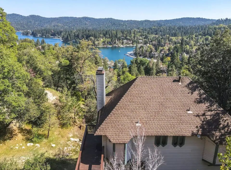 Drone view of cabin with lake behind.
