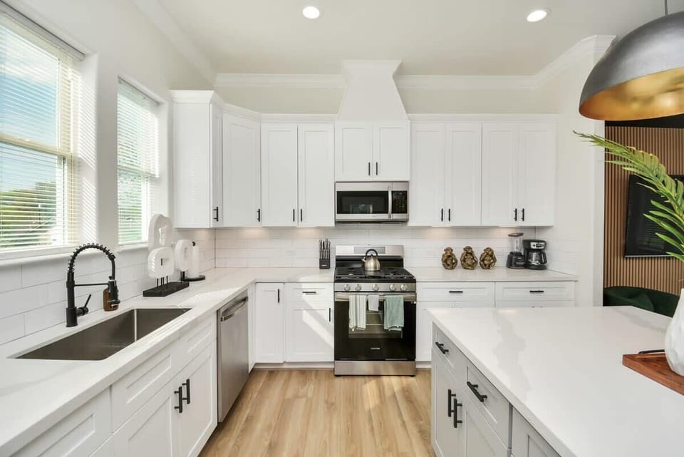 FULLY STOCKED Large Kitchen and Island. Accented with large gold pendant lights. Perfect for entertaining and hosting larger groups. 