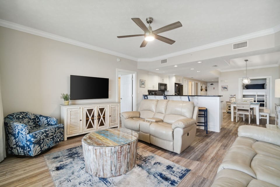 Open-concept living area with modern seating and a large flat-screen television.