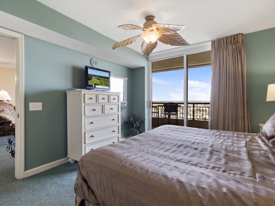 Wake up to stunning balcony views from your comfortable bedroom, where tropical ceiling fans keep you cool and peaceful green walls create a relaxing retreat.
