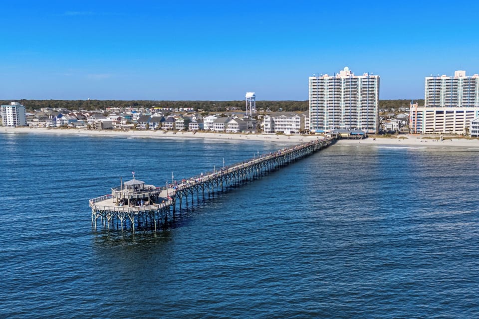 Aerial view showcasing the coastal area with beach, pier, and surrounding neighborhood—part of the property's scenic location near the waterfront and local attractions.