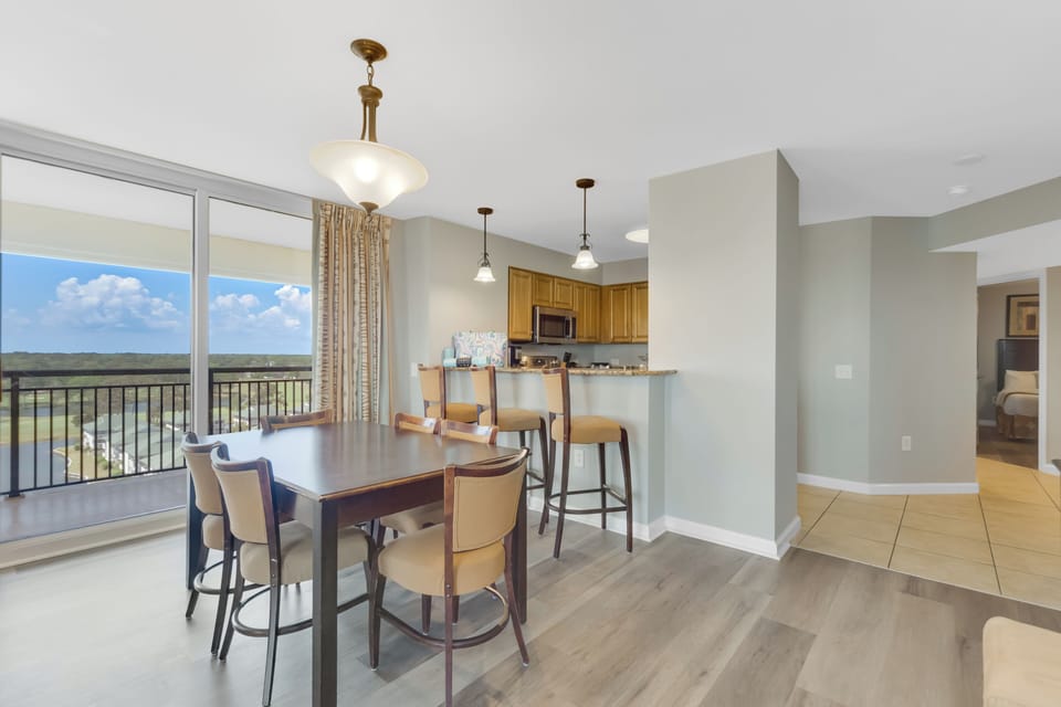 Gather around your spacious dining table while soaking in stunning views through floor-to-ceiling windows in this modern, open-concept space.