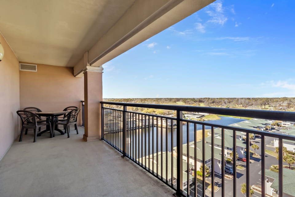 Unwind on your private balcony with dining table, overlooking the scenic landscape and marina below.