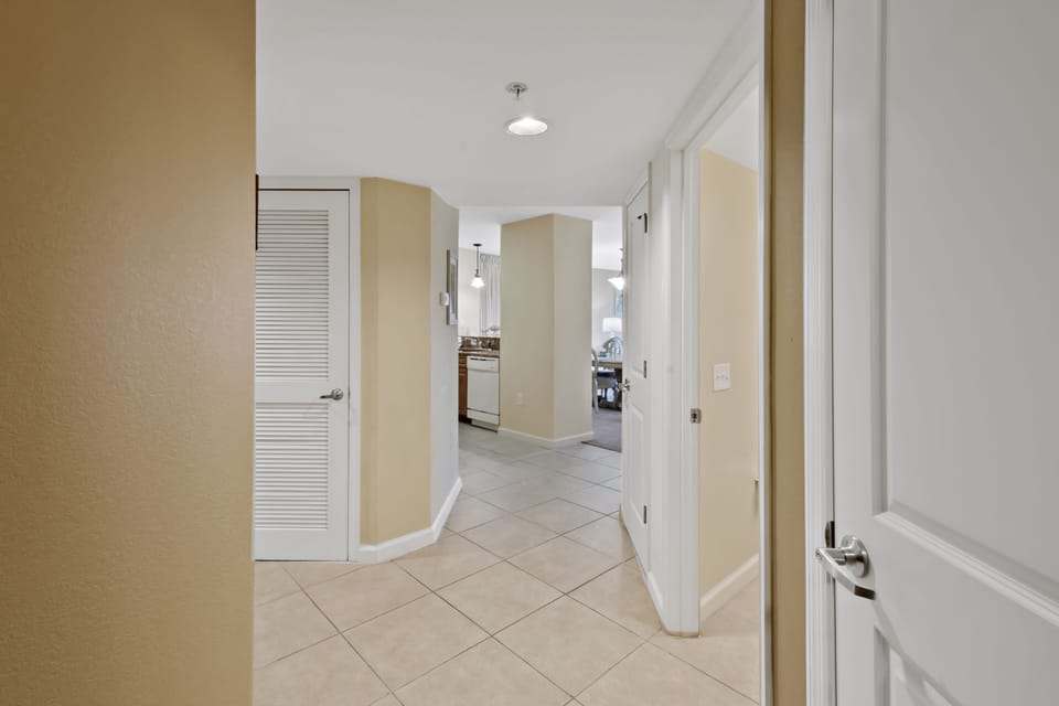 Step into your spacious entry hallway with gleaming tile floors and warm neutral tones that flow seamlessly into the bright, modern kitchen beyond.