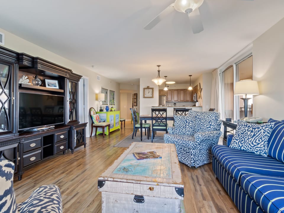 Relax in your spacious living area with coastal blue accents, hardwood floors, and open-concept design flowing into the modern kitchen.