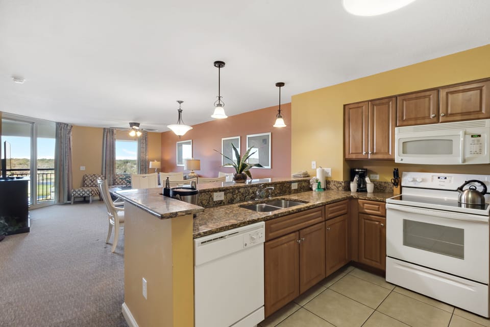 Your spacious kitchen features granite counters, modern appliances, and an open layout flowing into the living area with scenic views.