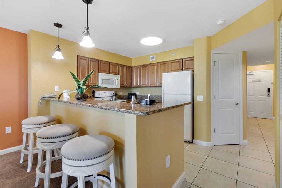Your fully equipped kitchen features granite counters, modern appliances, and a breakfast bar where you can enjoy coffee while planning your day.