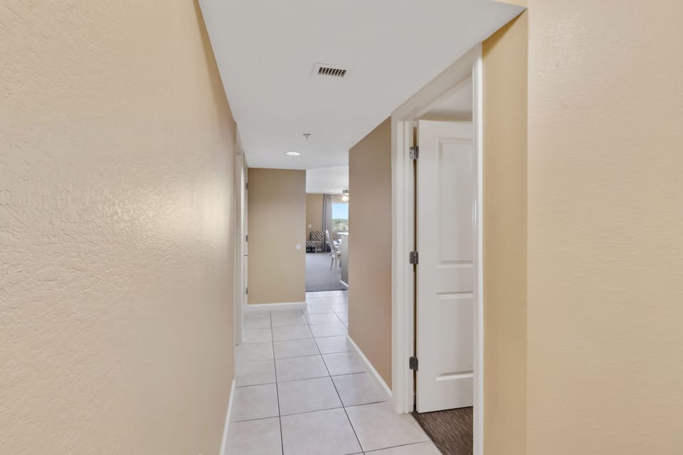 Your private hallway leads to spacious rooms with natural light streaming from the living area ahead.