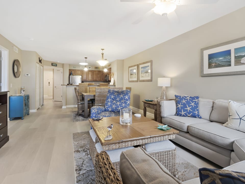 Relax in your spacious living room with coastal-inspired decor and open kitchen, perfect for entertaining or unwinding after beach days.