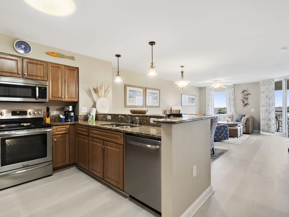 Your modern kitchen flows seamlessly into the living space, featuring granite counters, stainless appliances, and a breakfast bar perfect for morning coffee.