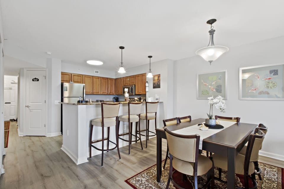 Your modern open-concept kitchen and dining area features warm wood cabinets, stainless appliances, and elegant seating for memorable meals.