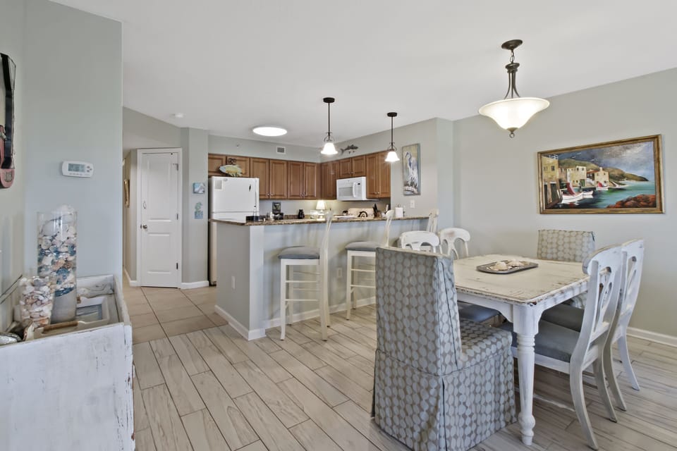 Your open-concept kitchen and dining space invites memorable meals with coastal charm, featuring granite counters and comfortable seating for six.