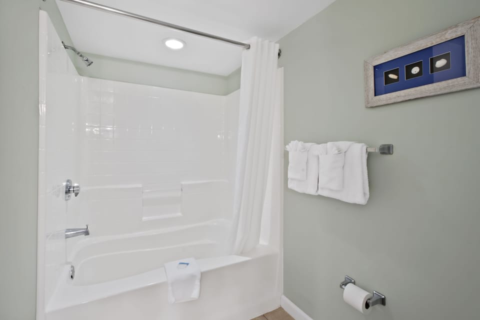 Your private bathroom features a modern tub-shower combo with fresh towels, perfect for unwinding after your adventures.