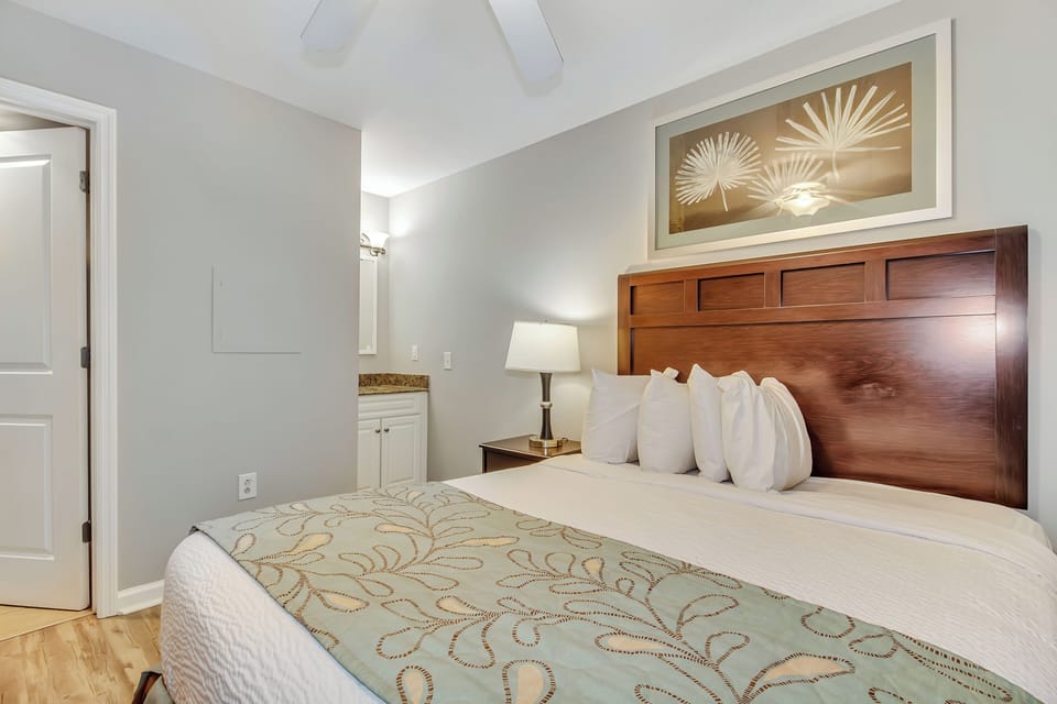 Sink into crisp linens and plush pillows in your serene bedroom, where warm wood tones and elegant decor create the perfect retreat.