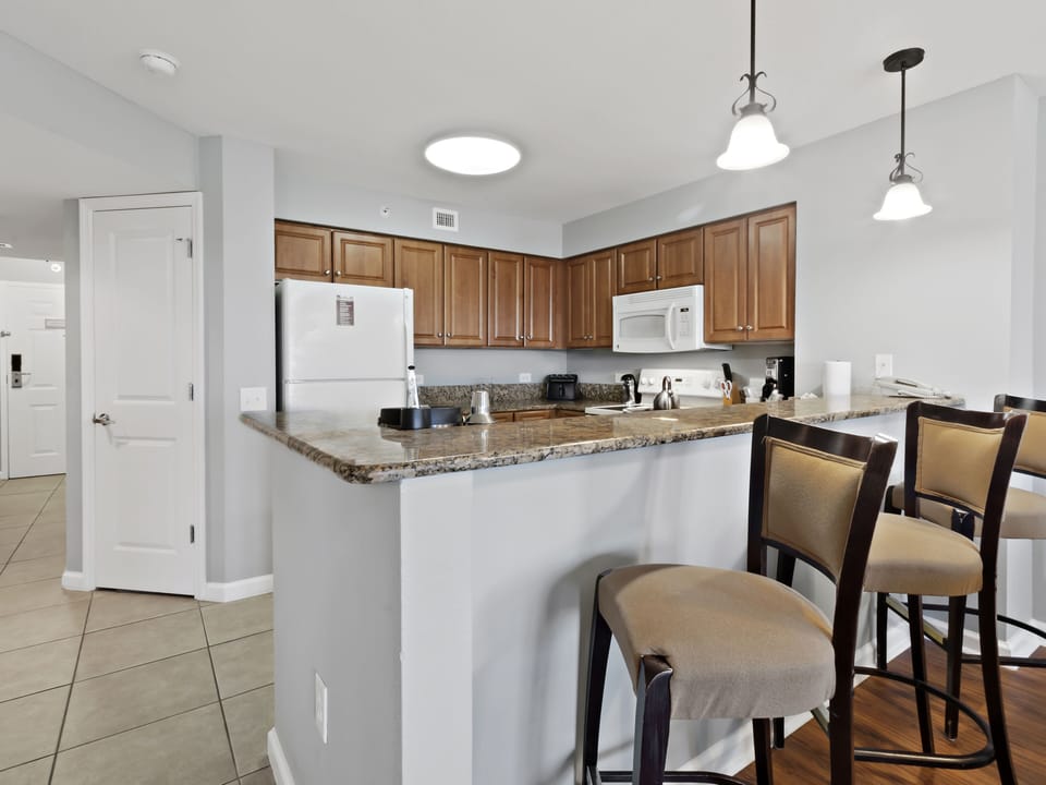 Your fully equipped kitchen features granite countertops, modern appliances, and a breakfast bar where you can enjoy morning coffee or casual meals.
