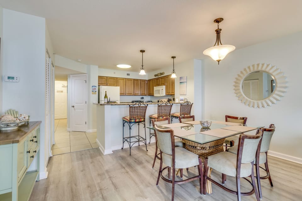 Gather around your elegant dining table while the open kitchen invites culinary adventures with warm wood cabinets and modern conveniences.