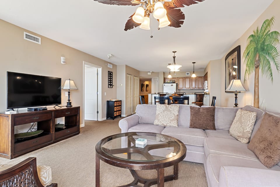 Relax on plush gray sectional seating while enjoying tropical decor and open-concept flow to your fully equipped kitchen.