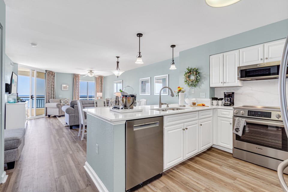 Your spacious kitchen flows seamlessly into the living area, where ocean breezes drift through balcony doors and modern appliances await your culinary adventures.