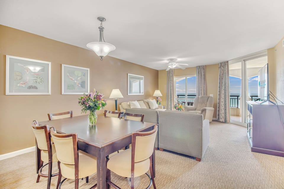 Relax in your elegant living space with comfortable seating and dining for six, where ocean views through floor-to-ceiling windows create the perfect backdrop.