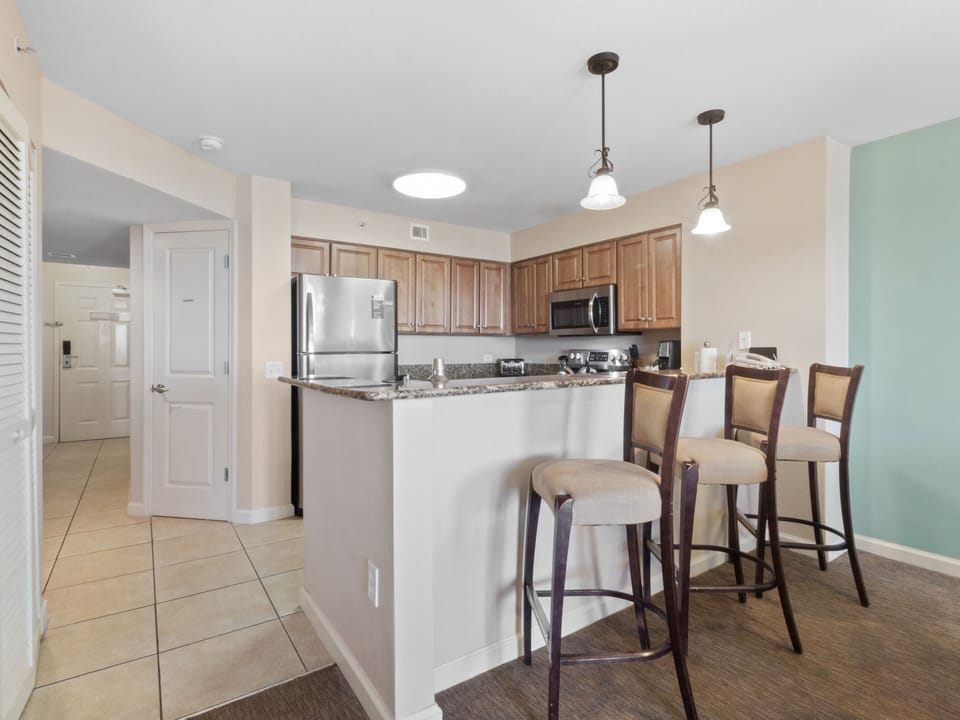 Your fully equipped kitchen features granite countertops, stainless appliances, and a breakfast bar perfect for morning coffee or casual dining.