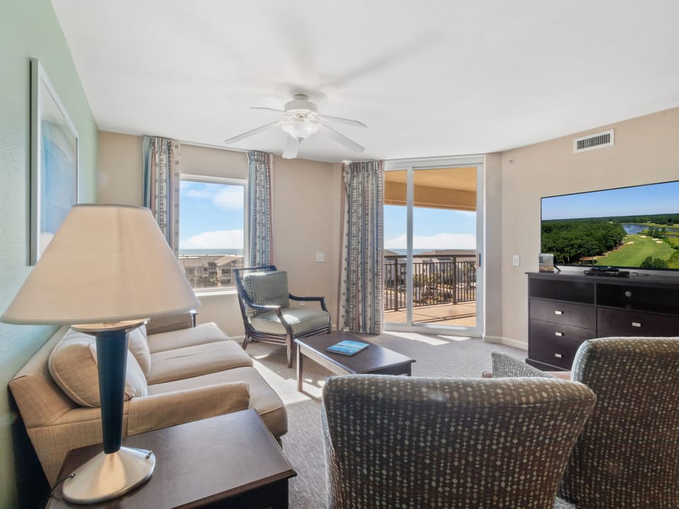 Relax in your bright living room with comfortable seating and enjoy the scenic golf course views from your private balcony.