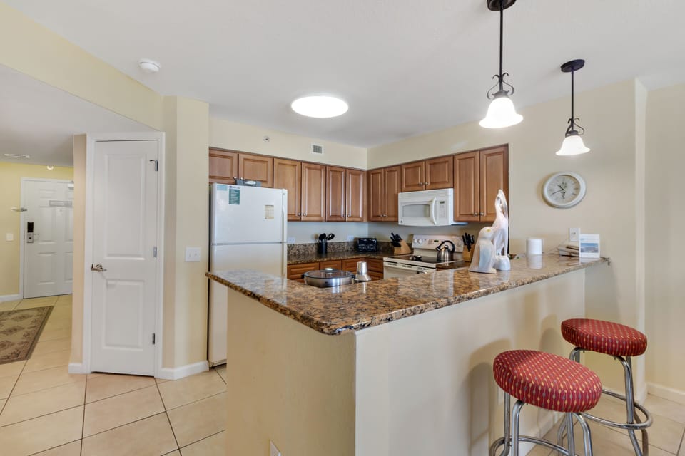 Your fully equipped kitchen features granite countertops, modern appliances, and a breakfast bar where you can start each morning.