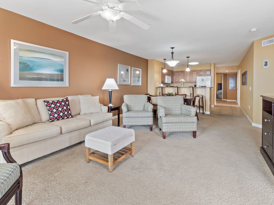Relax in your spacious living room with plush seating, warm decor, and an open layout connecting to the fully equipped kitchen.