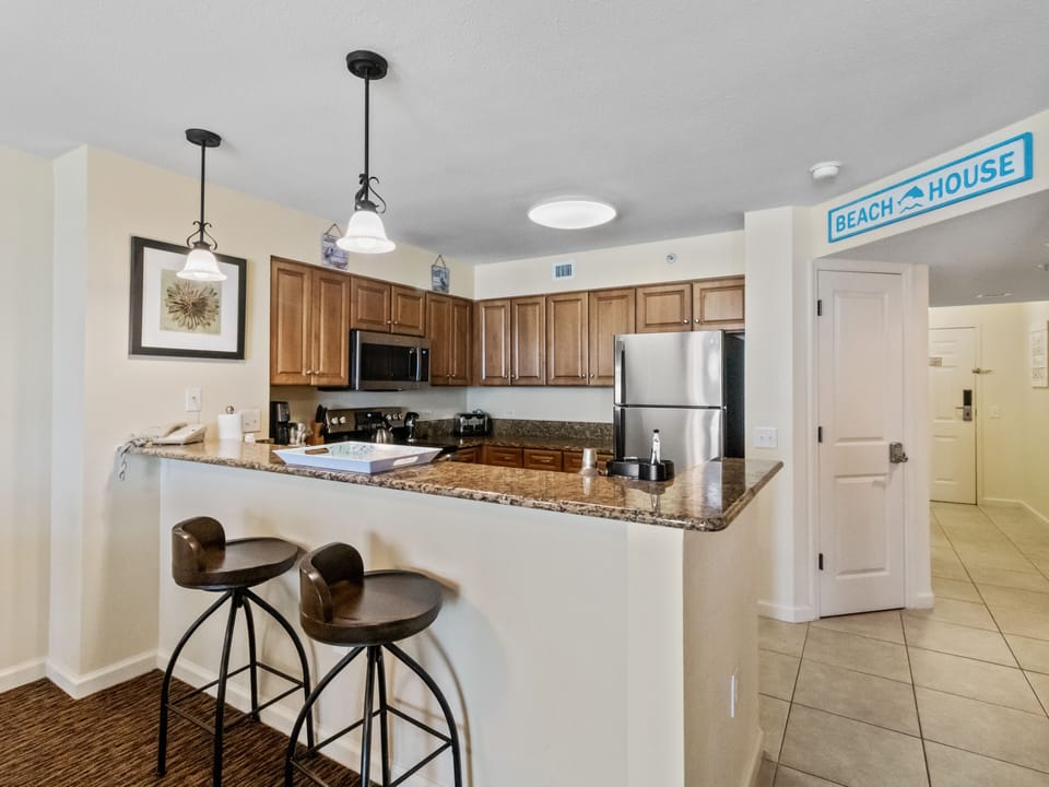 Cook your favorite meals in this fully equipped kitchen featuring granite counters, stainless appliances, and a breakfast bar perfect for morning coffee.