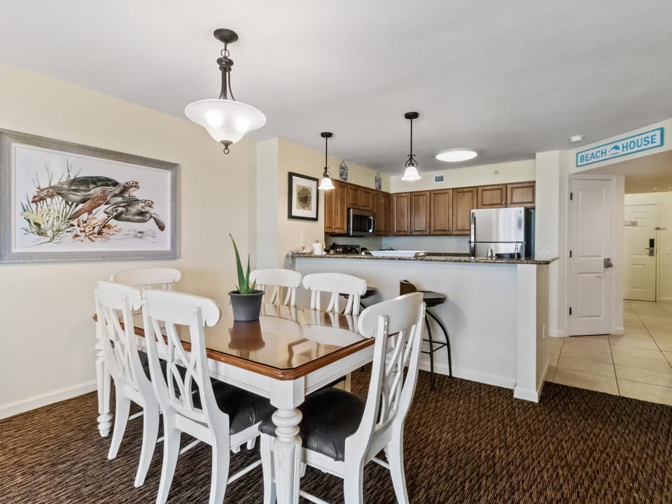 Your open-concept kitchen and dining space feels bright and beachy, perfect for preparing meals and gathering together during your coastal getaway.