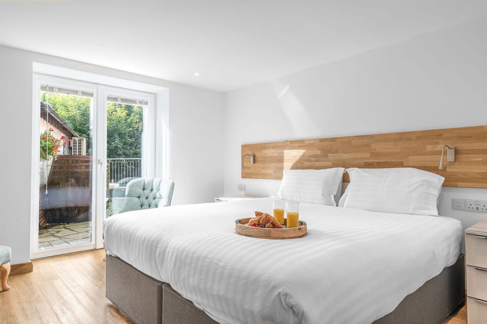 Forge Bridge House bedroom 1 with patio doors to riverside patio