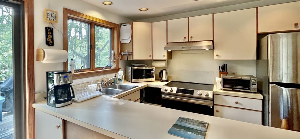 Spacious and fully stocked eat-in kitchen opens up to deck with sliding doors