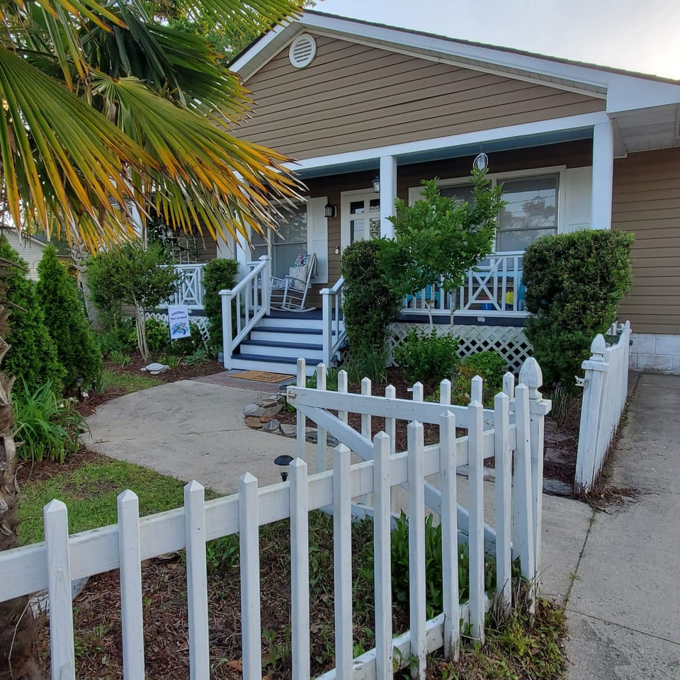 Lovely white picket fence around the front yard.  5' wooden fence in back.