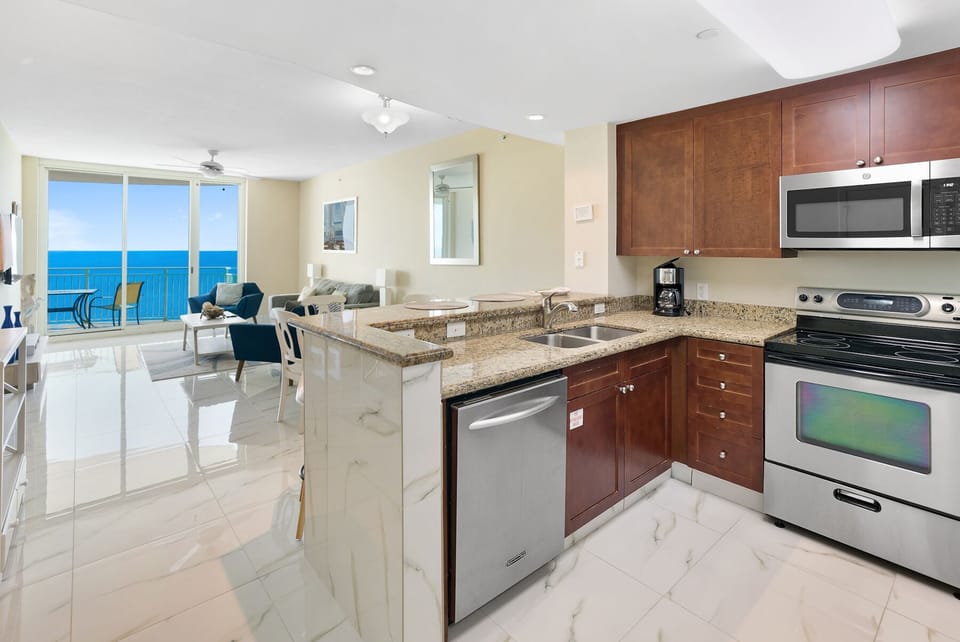 Your fully equipped kitchen opens to the living area with stunning ocean views through floor-to-ceiling windows.