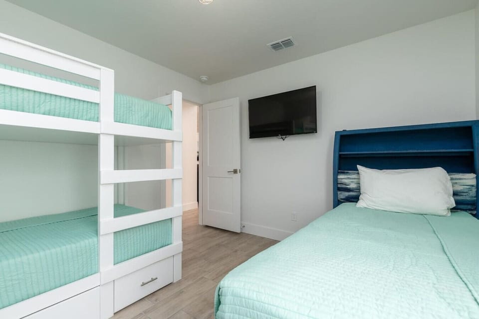 Family-friendly bunk room with a twin-over-twin bunk and queen bed—plenty of space for kids or cousins to crash together.