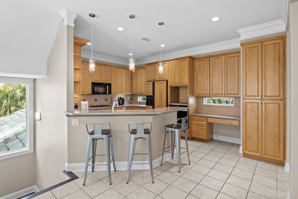Your spacious kitchen awaits with warm wood cabinets, granite counters, and a breakfast bar perfect for morning coffee.