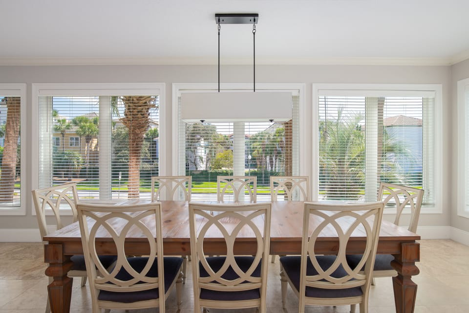 Gather around this elegant dining table where natural light streams through expansive windows, creating the perfect setting for memorable meals together.