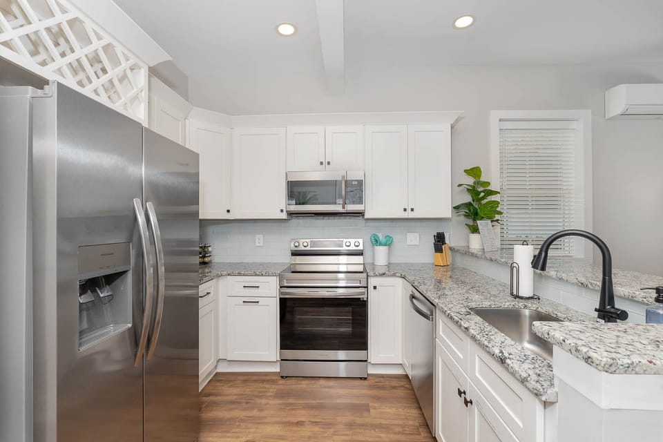 Kitchen with SS microwave, dishwasher, stove, and door ice & water dispenser.