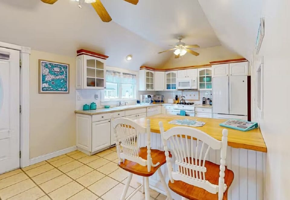 Map of Cape Cod, welcome book & more seating on other side of kitchen island. 