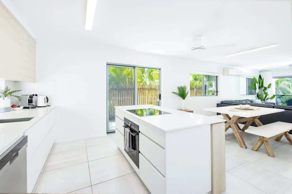 Prepare meals in the bright, contemporary kitchen, where generous bench space and leafy outlooks create an effortless holiday atmosphere.