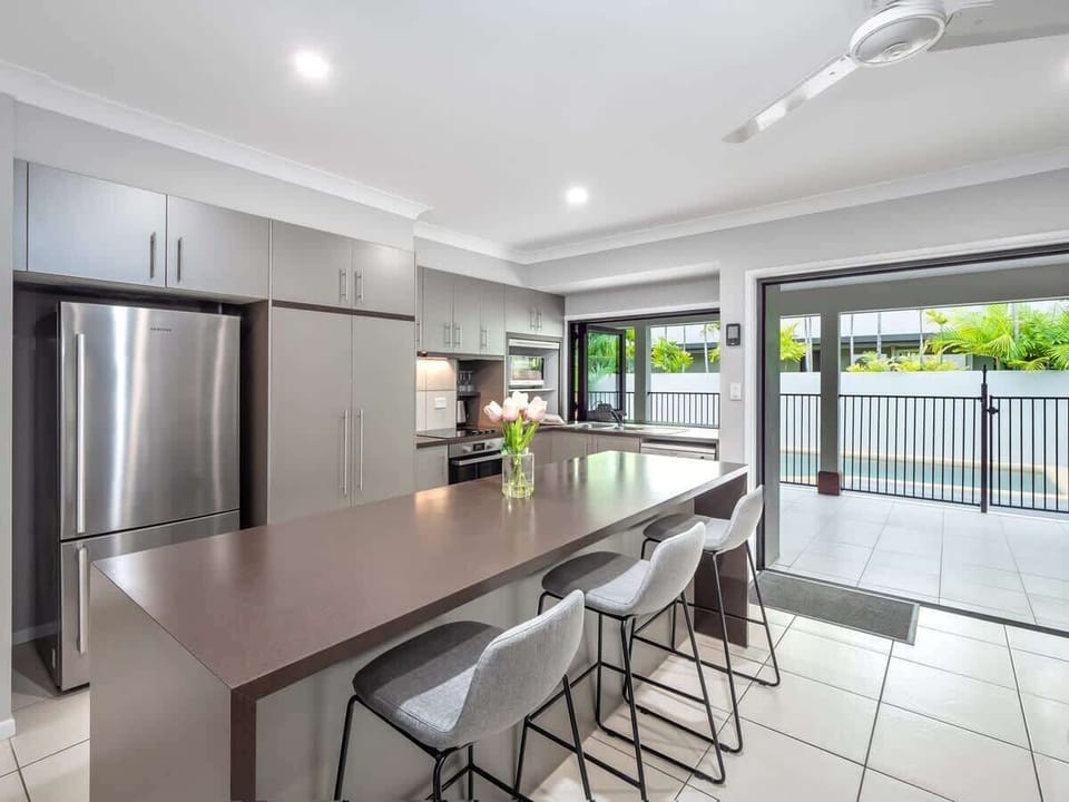 The modern kitchen makes holiday dining effortless, with expansive bench space, bar seating, and an easy connection to the patio for relaxed indoor-outdoor meals.