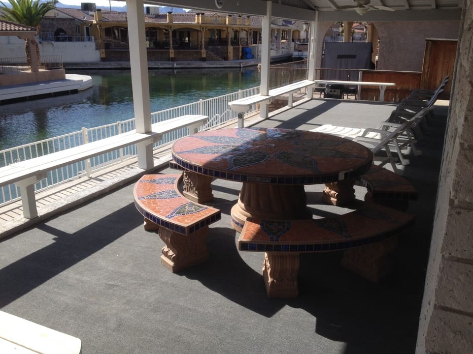 Extra large patio area with BBQ, lounge chairs, ceiling fans and shade.