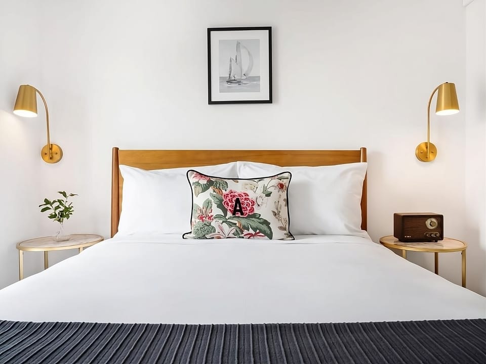 Drift off in a serene bed framed by soft sconces.