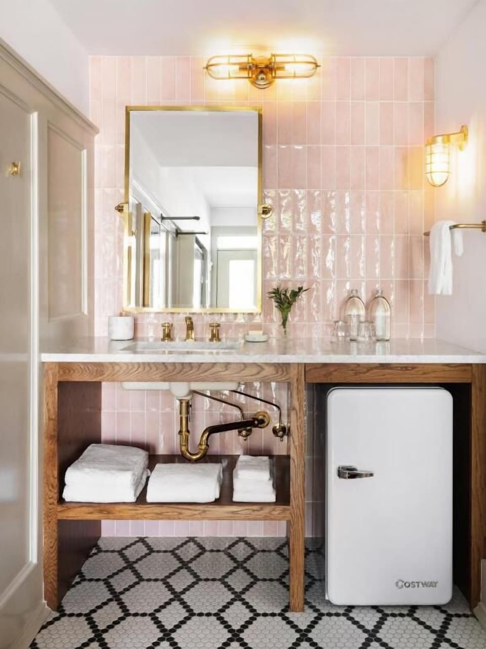 Refresh at the glam pink-tile vanity with luxe brass fixtures.